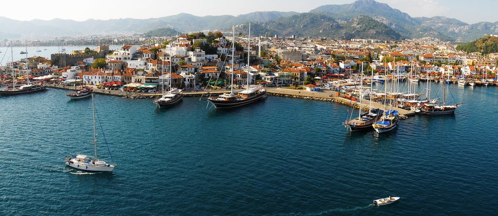 Aerial view of Marmaris harbour, waterfront, yachts and surrounding mountains in Türkiye.